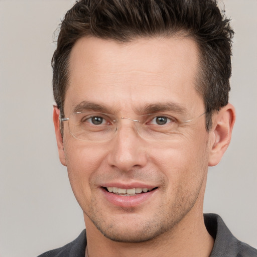 Joyful white adult male with short  brown hair and grey eyes