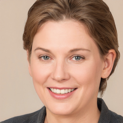 Joyful white adult female with medium  brown hair and grey eyes