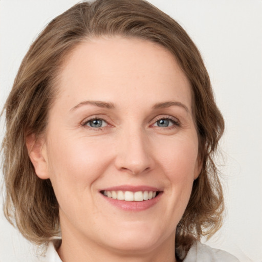 Joyful white young-adult female with medium  brown hair and green eyes