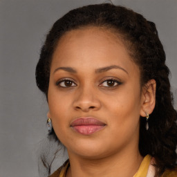 Joyful black young-adult female with long  brown hair and brown eyes