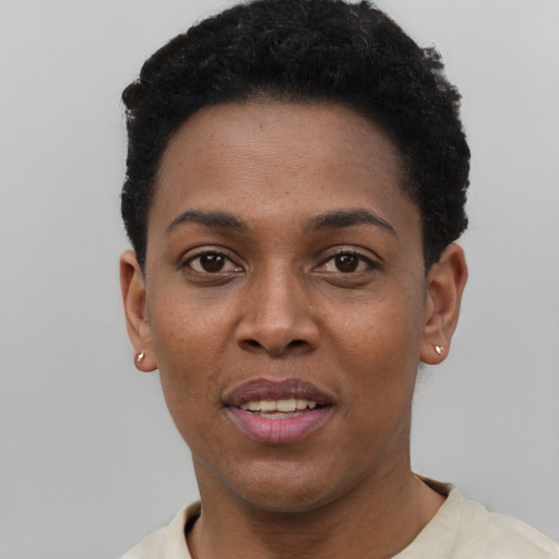 Joyful black young-adult female with short  black hair and brown eyes