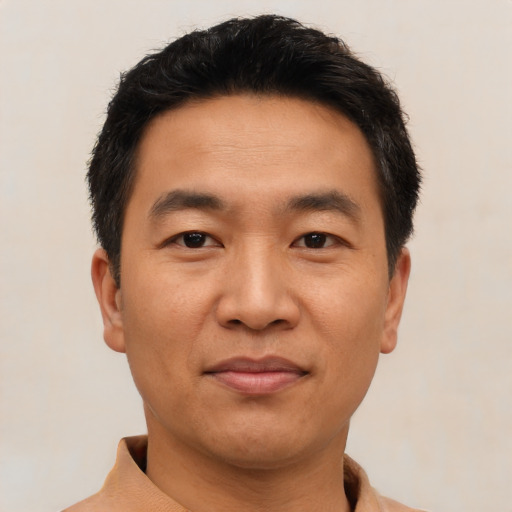 Joyful asian adult male with short  brown hair and brown eyes