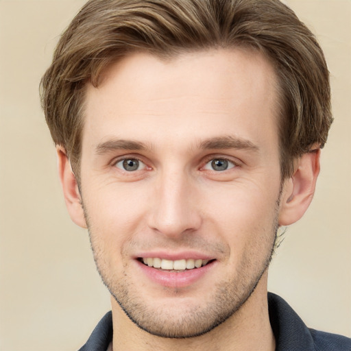 Joyful white young-adult male with short  brown hair and grey eyes