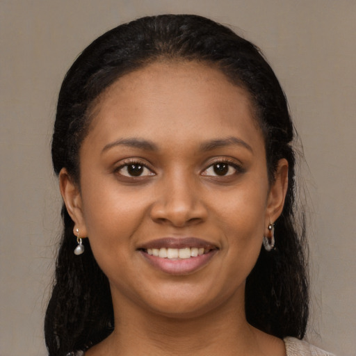 Joyful black young-adult female with long  black hair and brown eyes