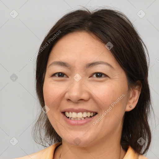 Joyful white adult female with medium  brown hair and brown eyes