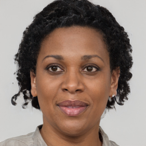 Joyful black adult female with short  brown hair and brown eyes