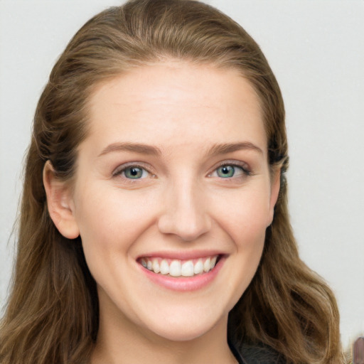 Joyful white young-adult female with long  brown hair and blue eyes