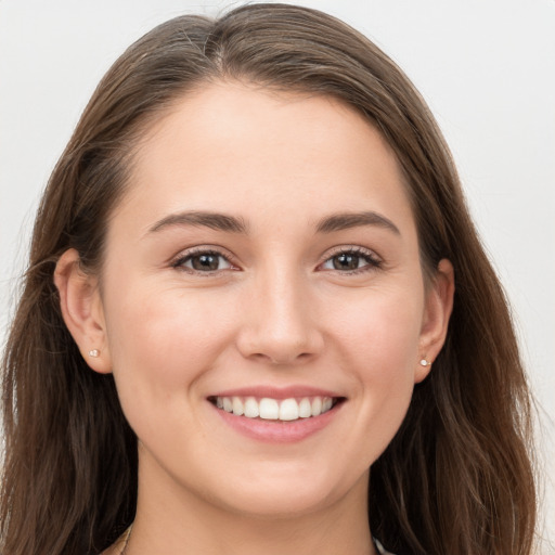 Joyful white young-adult female with long  brown hair and grey eyes