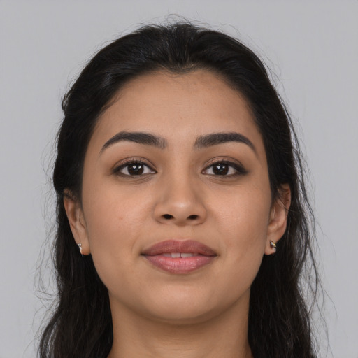 Joyful latino young-adult female with long  brown hair and brown eyes