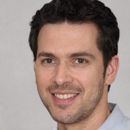 Joyful white adult male with short  brown hair and brown eyes