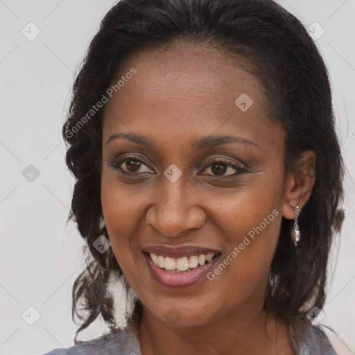 Joyful black adult female with long  brown hair and brown eyes