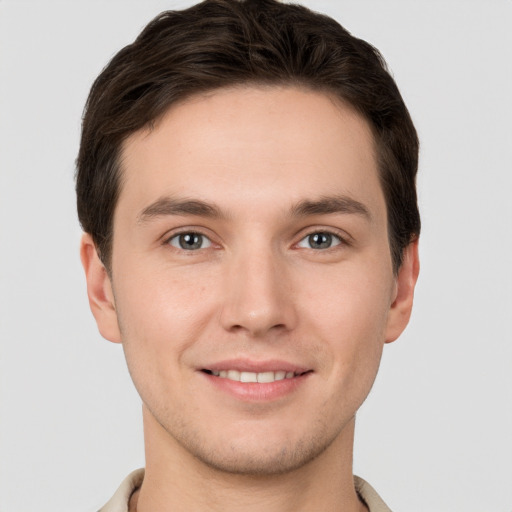 Joyful white young-adult male with short  brown hair and grey eyes