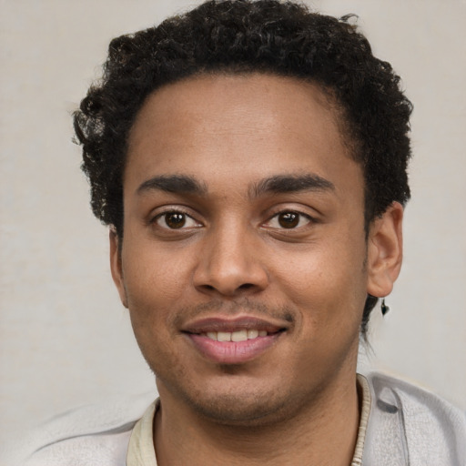 Joyful black young-adult male with short  black hair and brown eyes