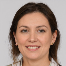 Joyful white adult female with medium  brown hair and grey eyes