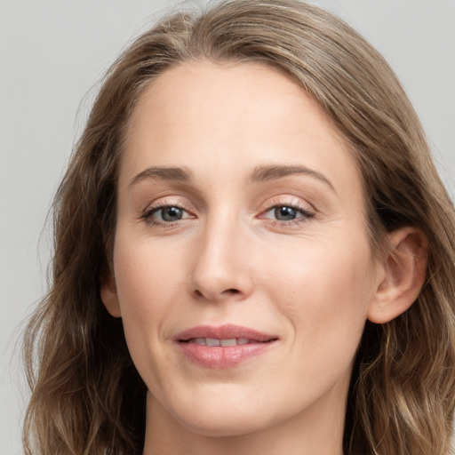 Joyful white young-adult female with long  brown hair and blue eyes