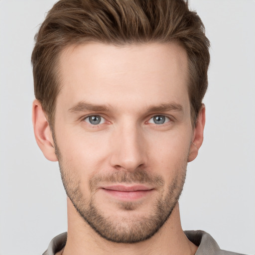 Joyful white young-adult male with short  brown hair and grey eyes