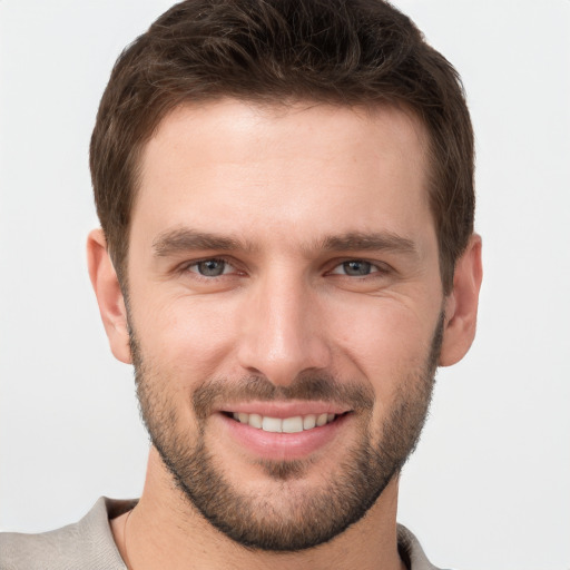 Joyful white young-adult male with short  brown hair and grey eyes