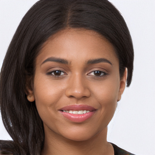 Joyful black young-adult female with long  brown hair and brown eyes