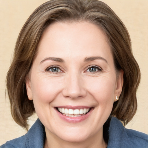 Joyful white adult female with medium  brown hair and grey eyes