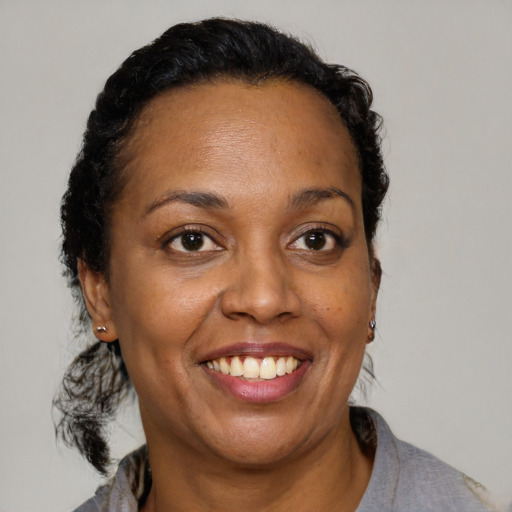 Joyful black adult female with short  brown hair and brown eyes