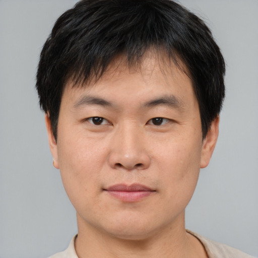 Joyful asian young-adult male with short  brown hair and brown eyes