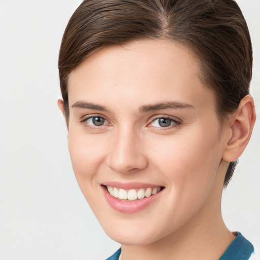 Joyful white young-adult female with medium  brown hair and grey eyes