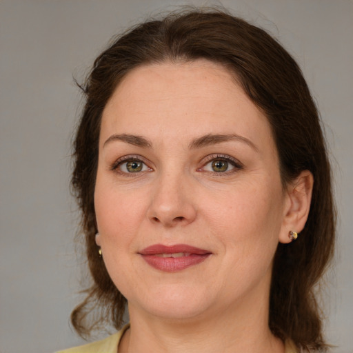 Joyful white adult female with medium  brown hair and green eyes