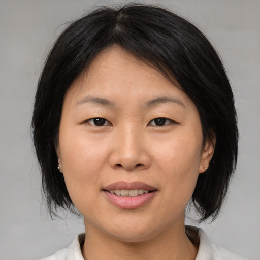 Joyful asian young-adult female with medium  brown hair and brown eyes