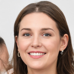 Joyful white young-adult female with long  brown hair and blue eyes