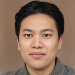 Joyful asian young-adult male with short  black hair and brown eyes