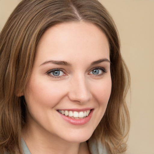 Joyful white young-adult female with long  brown hair and green eyes