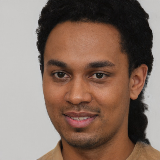 Joyful black young-adult male with short  black hair and brown eyes