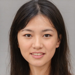 Joyful asian young-adult female with long  brown hair and brown eyes