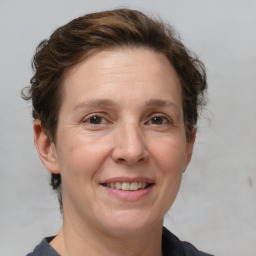 Joyful white adult female with medium  brown hair and grey eyes