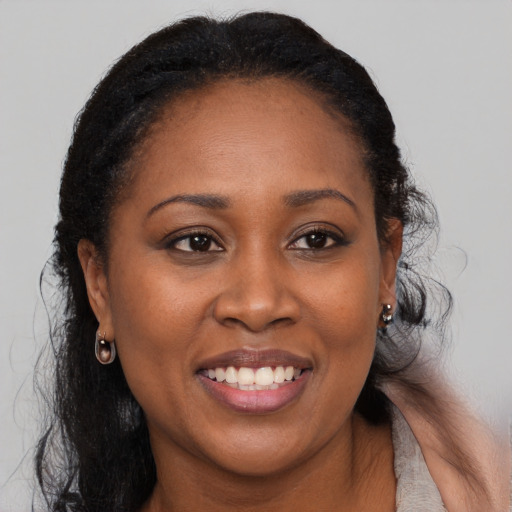 Joyful black adult female with long  brown hair and brown eyes