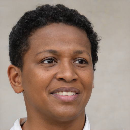 Joyful black young-adult female with short  brown hair and brown eyes