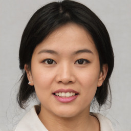 Joyful asian young-adult female with medium  black hair and brown eyes