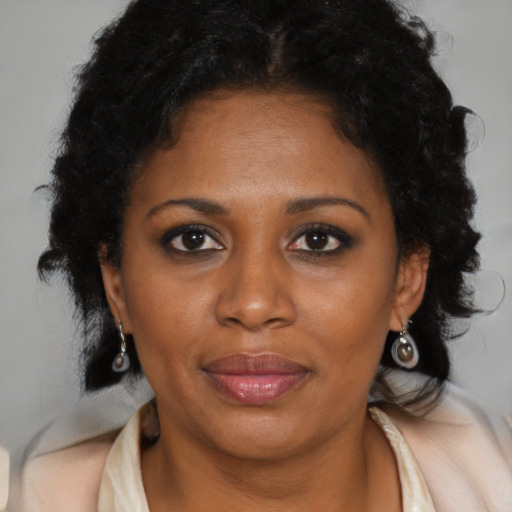 Joyful black adult female with long  brown hair and brown eyes