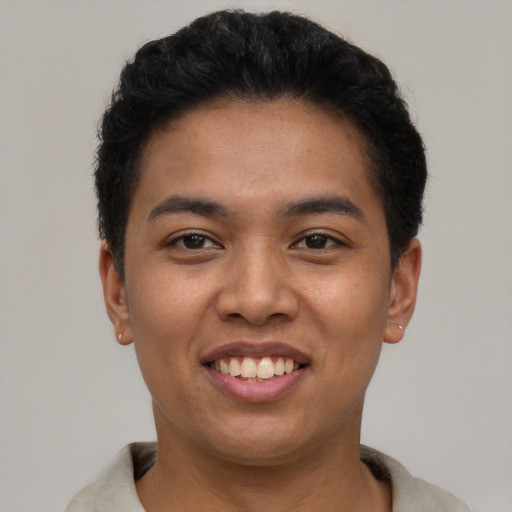 Joyful latino young-adult male with short  black hair and brown eyes
