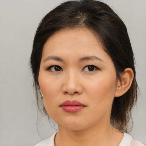 Joyful asian young-adult female with medium  brown hair and brown eyes