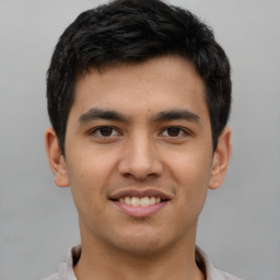 Joyful latino young-adult male with short  brown hair and brown eyes