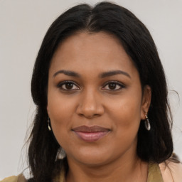 Joyful black young-adult female with long  brown hair and brown eyes