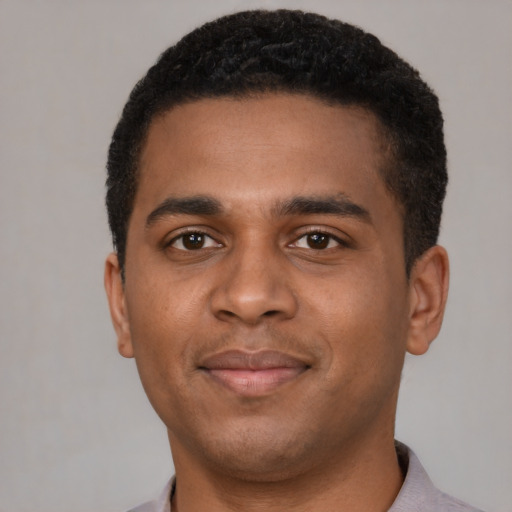Joyful black young-adult male with short  brown hair and brown eyes