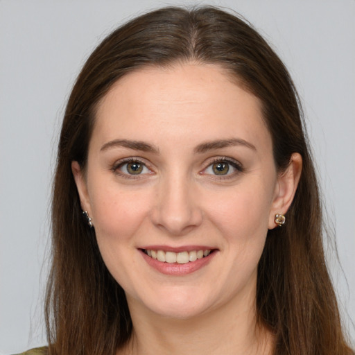 Joyful white young-adult female with long  brown hair and brown eyes