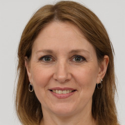 Joyful white adult female with long  brown hair and grey eyes