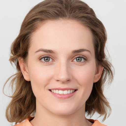 Joyful white young-adult female with medium  brown hair and green eyes