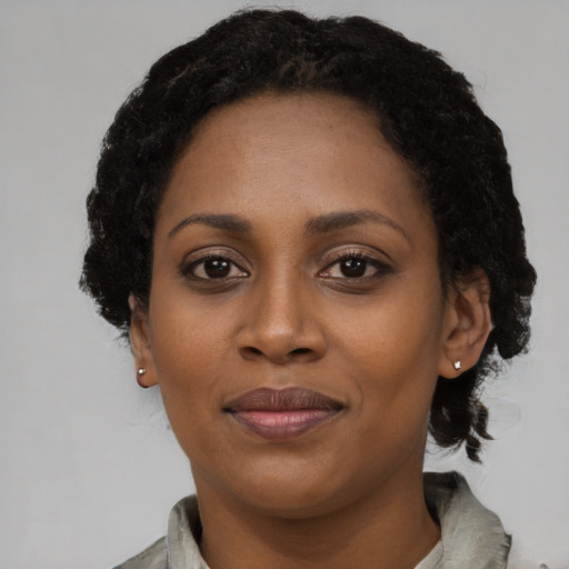 Joyful black young-adult female with short  black hair and brown eyes