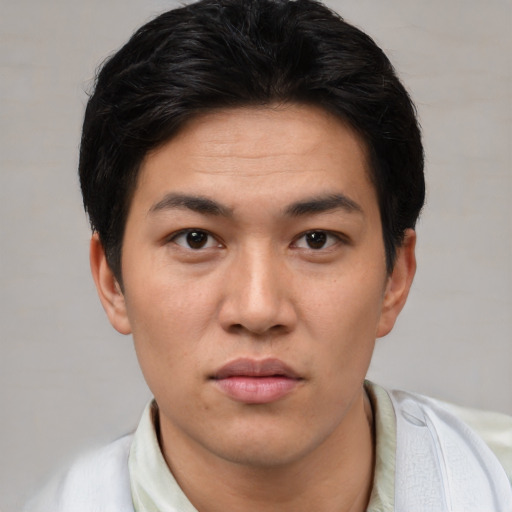 Joyful asian young-adult male with short  black hair and brown eyes