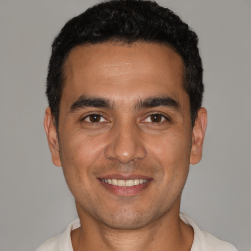 Joyful latino young-adult male with short  black hair and brown eyes