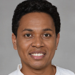 Joyful black adult male with short  black hair and brown eyes